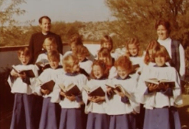 Children and adults in choir robes gathered for a parish photograph.