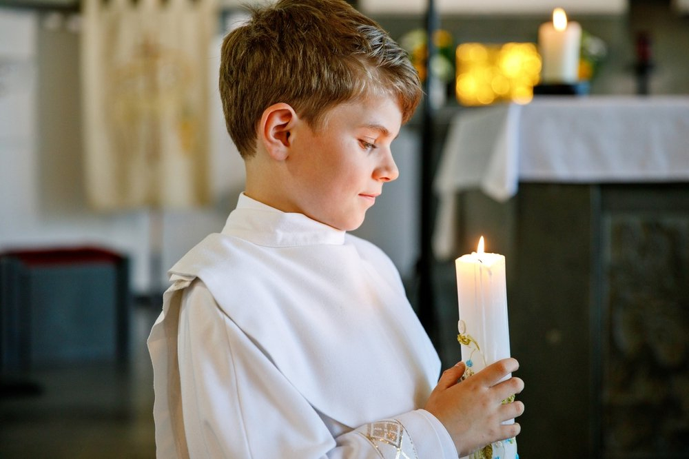 A child holding a candle in church.
