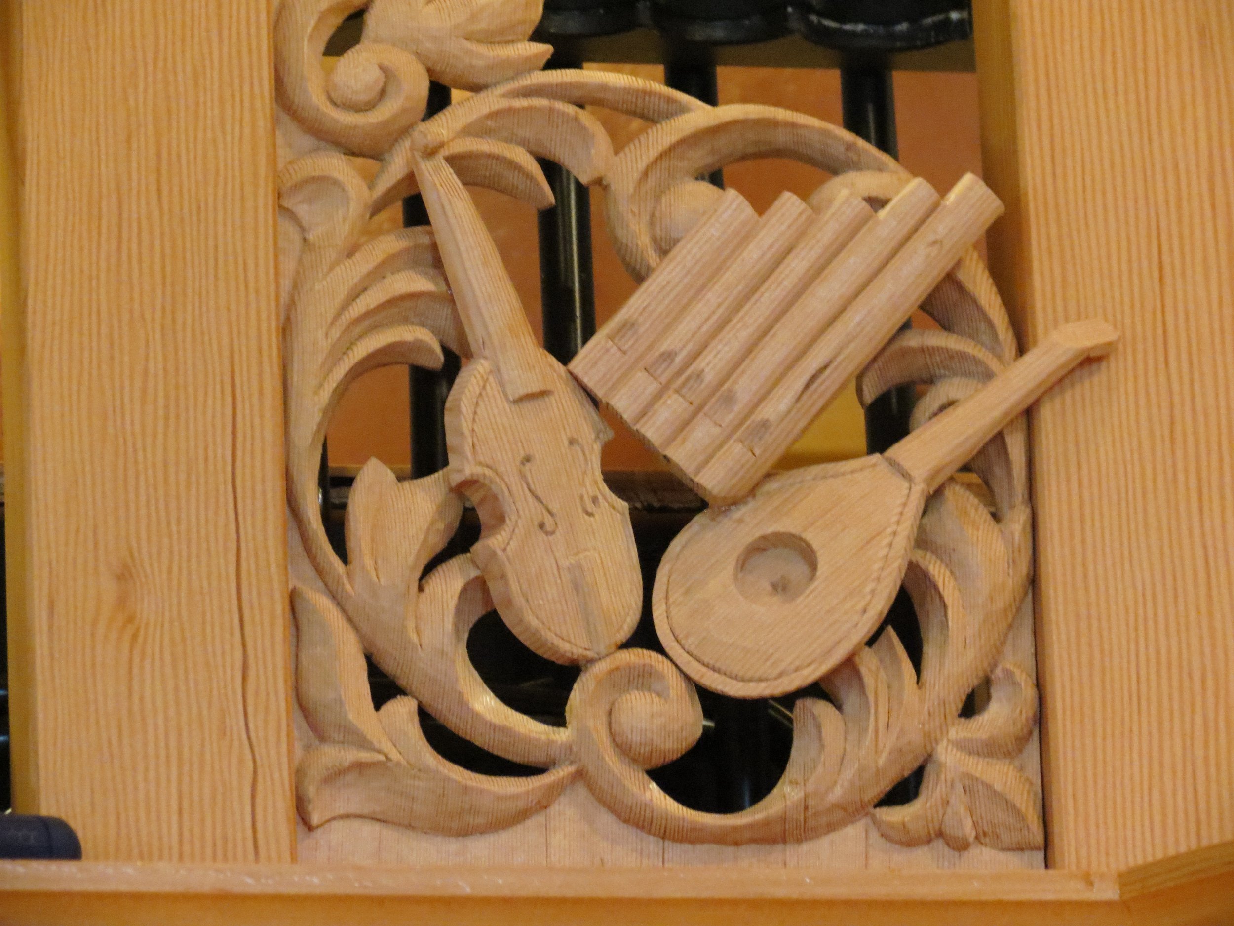 Carved musical instruments decorating the Fritts organ case.